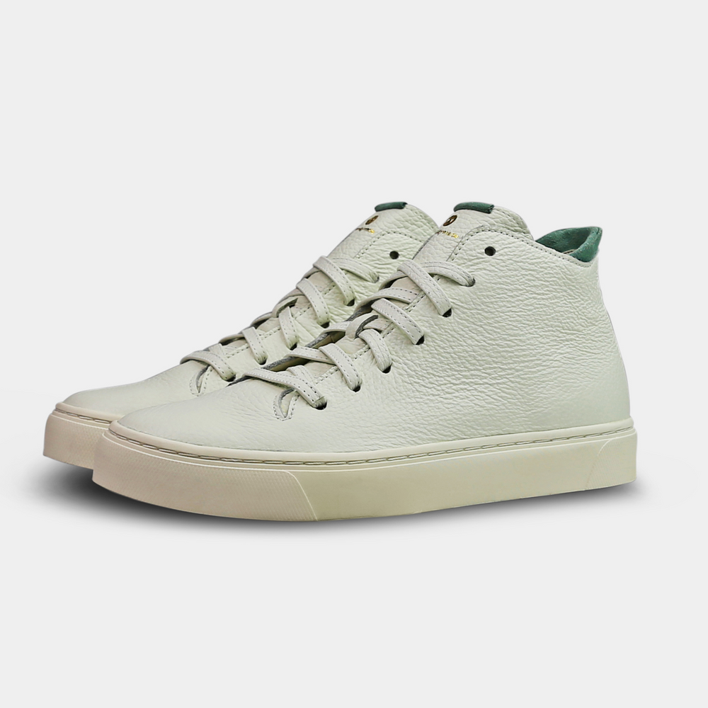 
                      
                        A white, mid-top sneaker with a leather upper, lace-up closure, and a white sole quarter view
                      
                    