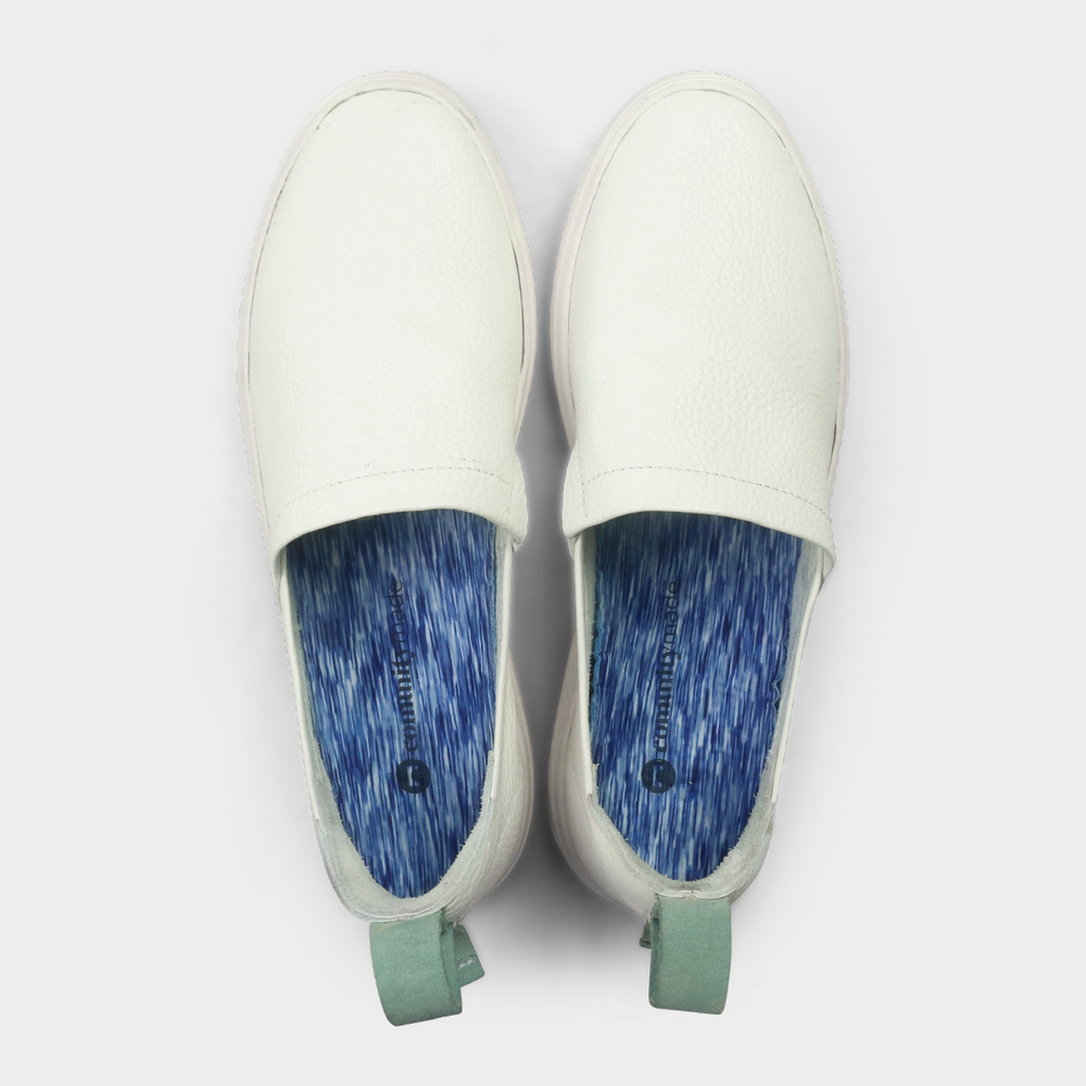 
                      
                        A white slip-on men's shoe with a suede and leather upper and a rubber sole top view
                      
                    